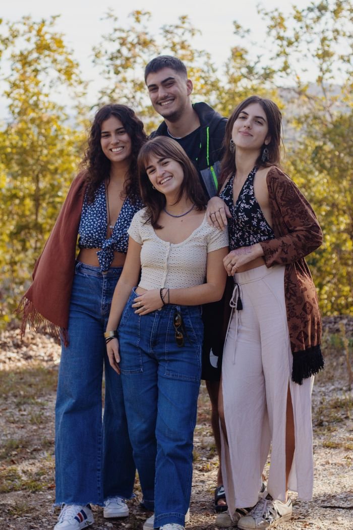 A group of young friends smiling and standing together outdoors during autumn. Vibrant and lively mood.